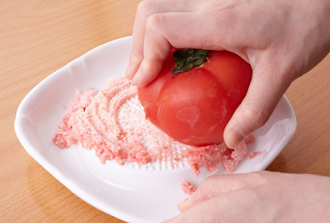 冷凍庫で凍らせておいたトマトを凍ったまますりおろし、ボウルに入れる。