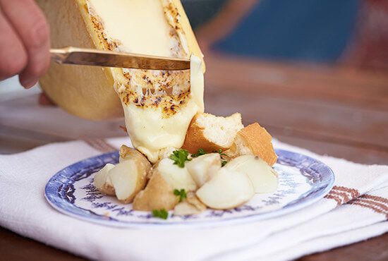 チーズの断面を直火で炙り、トロトロに溶けたところでお好みの食材（今回はボイルドポテト）にブッかけて食べるという逸品だ。