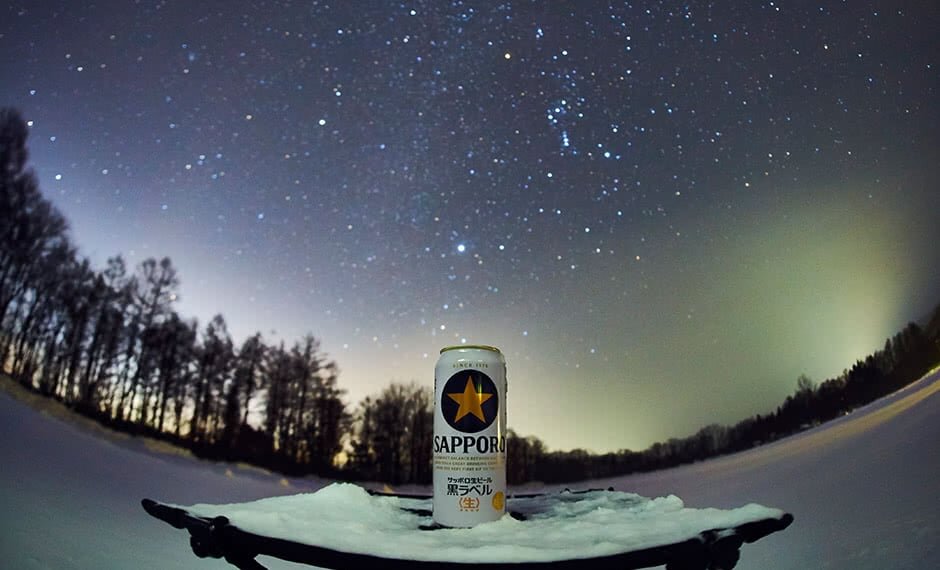 素晴らしい雪景色と冬の星空の下、星のビールで乾杯！