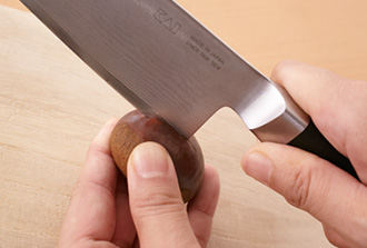 栗の側面に包丁の刃の根元を差し込むようにして（片手で栗をしっかり持ち、刃がすべらないよう注意して）、横に切り込みを入れる。