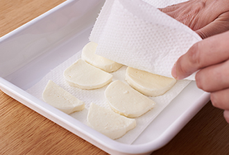 モッツァレラチーズは6等分の輪切りにし、それぞれ半分に切って12枚にする。ペーパータオルで包み、しっかりおさえて水気をとる。オリーブは幅5ミリの輪切りにする。