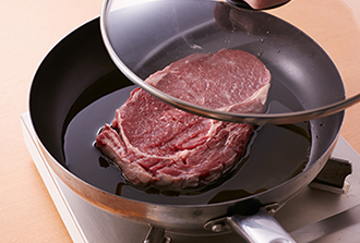 牛肉は冷蔵庫から出して30分以上おいて常温に戻しておく。脂肪と赤身の間に切り込みを入れ、塩をふる。フライパンにオリーブ油と牛肉を入れてふたをし、強火で1分蒸し焼きにする。上下を返して再びふたをし、さらに1分蒸し焼きにする。