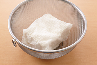 豆腐をペーパータオルで包んでざるにのせ、10分ほどおいて水気をきって12等分に切る。