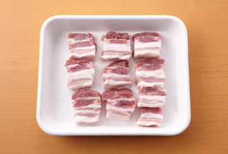 豚肉は一口大に切って塩小さじ1/2をもみ込み、10分おく。ソーセージは幅1センチに切り、玉ねぎは薄切りにする。にんにくは半分に切って芯を取り、つぶす。