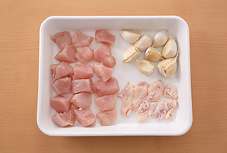鶏肉は皮と身を分けてそれぞれ一口大に切る。にんにくは薄皮をつけたまま使う。