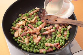 玉ねぎはみじん切りにする。エリンギは長さを3等分に切って、縦に幅7～8ミリに切る。ベーコンは8ミリ角（薄切りの場合は幅1センチ）に切る。フライパンにオリーブオイルを中火で熱し、玉ねぎ、ベーコン、エリンギの順に加えて炒める。玉ねぎがしんなりとしたらグリンピースも加えて炒め、顆粒スープの素、塩、こしょう、湯1カップを加えて混ぜ、ふたをして10分ほど、汁気がなくなるまで煮る。