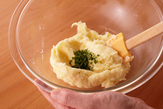 ポテト生地を作る。じゃがいもは皮つきのままラップで包んで電子レンジ600Wで5～6分加熱する。皮をむいてボウルに入れてつぶし、熱いうちに牛乳、バター、塩、こしょうを加えてなめらかになるまで混ぜる。パセリを加えて混ぜ、6等分にして丸める。