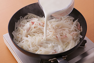フライパンにサラダ油を中火で熱し、ベーコン、大根、玉ねぎを炒める。しんなりしてきたら塩を加えて牛乳を注ぎ入れ、野菜がやわらかくなるまで煮る。