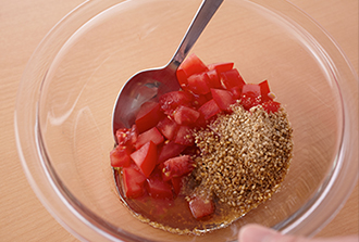 トマトを1センチ角に切ってボウルに入れ、ドレッシングの材料を加えて混ぜ合わせる。