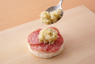 カマンベールチーズは厚みを半分に切り、下半分のチーズにサラミをのせる。さらにその上に1をのせる。