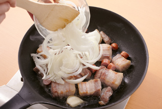 フライパンにサラダ油を中火で熱し、豚肉を焼きつける。薄く焼き色がついて脂が出てきたらソーセージ、玉ねぎ、にんにく、ローリエを加え、玉ねぎがしんなりするまで炒める。