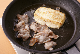 豚肉に塩、黒こしょう各少々をふる。フライパンにサラダ油を中火で熱し、豚肉を炒め、空いているところに豆腐を切らずにそのまま入れて両面焼きつける。肉に焼き色がつき、豆腐もこんがりしたらいったん取り出す（油はフライパンに残す）。