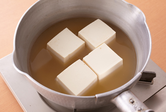 鍋に水と顆粒だしの素を入れて煮立たせ、豆腐を入れて弱めの中火で3分ほど煮る。豆腐が温まったら豆腐だけ取り出して器に盛る。