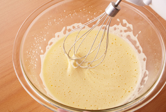 生地を作る。ボウルに卵を溶きほぐし、砂糖を加えて泡立て器でしっかり混ぜ合わせる。オリーブ油を少しずつ加え、その都度よく混ぜる。牛乳、塩、こしょうも加えてよく混ぜる。