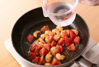 フライパンにオリーブ油とにんにくを入れて中火で炒める。香りが出たらえびを加えて炒め、色が変わったらトマトを加えて炒め、水1/2カップを加える。
