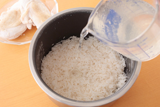 米はさっと洗い、ざるに上げて水気をきる。炊飯器に入れ、鶏肉のゆで汁2と1/2カップを加える（足りなければ水をたす）。上にゆでた鶏肉をのせ、普通に炊く。ご飯が炊き上がったら鶏肉を取り出し、Aを加えてさっくりと混ぜ合わせる。