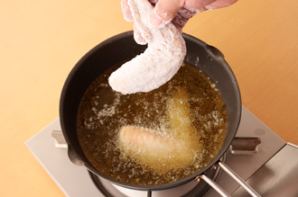 塩、こしょうをたっぷりふり、全体に小麦粉をまぶしつける。2つのバットに、白いりごま、黒いりごまを入れておく。揚げ油を中温に熱し、手羽先を入れる。ときどき上下を返しながら10分くらい、じっくり揚げて取り出し、油をきる。