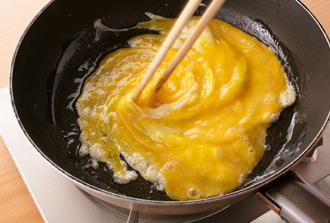 フライパンにサラダ油大さじ1を強火で熱し、溶き卵を一気にながし入れる。大きく混ぜて半熟状になったらいったん取り出す。
