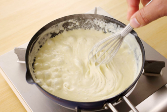 ホワイトソースを作る。別のフライパン（または鍋）にバターを中火で溶かし、小麦粉を加えて泡立て器でよく混ぜる。粉っぽさがなくなったら生クリームを加え、弱火にしてよく混ぜる。小麦粉が溶けたら顆粒スープの素、塩、こしょうを加え、とろりとするまで混ぜて火を止める。