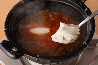 水を加え、煮立ったらアクを取る。おぼろ豆腐をスプーンで大きくすくって入れ、あさりのむき身も加える。ひと煮立ちしたら塩、こしょうで味をととのえる。