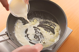ホワイトソースを作る。フライパンに、ホワイトソースのバターを入れて弱火で溶かす。薄力粉を加えて、泡立て器でしっかりと混ぜ、粉っぽさがなくなったら牛乳、生クリームをくわえる。顆粒スープの素、塩、こしょうを加え、とろみがついたら火を止める。