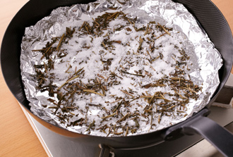 中華鍋（または深さのある鉄のフライパン）にアルミホイルを敷き、茶葉、砂糖をしいて焼き網をのせる。