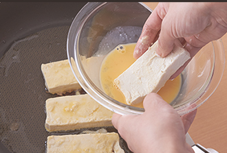 ボウルに卵を割り入れ溶きほぐし、塩、水を加えて卵液を作る。豆腐に薄力粉を薄くまぶす。フライパンにサラダ油を中火で熱し、豆腐を卵液にからめて並べ、両面に焼き色がつくまで焼いて器に盛り、ピリ辛ねぎだれを添える。