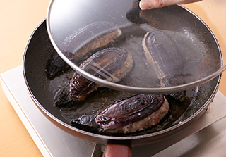 フライパンにオリーブ油を中火で熱し、なすの皮を下にして入れる。3分ほど焼いたら裏返してふたをし、さらに3分ほど蒸し焼きにして皿に盛る。