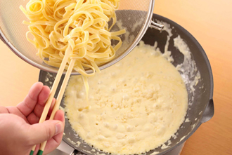 フェットチーネをゆでてクリームソースに加え、パルメザンチーズを加えてからめる。器に盛り、金目鯛を上にのせ、イタリアンパセリを添える。