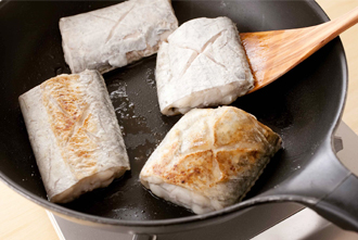 つけ合わせを作る。フライパンにオリーブ油大さじ1を中火で熱し、ズッキーニを炒める。玄米ご飯を加えて炒め合わせ、塩、こしょうをふって、トマトを加えてざっと混ぜたら、皿に盛る。フライパンにオリーブ油少々をたし、太刀魚に小麦粉をまぶして入れる。強めの中火で3～4分、裏返してさらに3～4分焼き、こんがりしたら皿に盛る。バジルソースをかけ、フレッシュバジル（分量外）少々を添える。