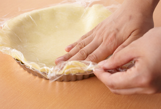 タルト型にバター少々（分量外）を塗って薄力粉少々（分量外）をまぶし、3の生地を敷き詰める。はみ出した部分は切り落とす。