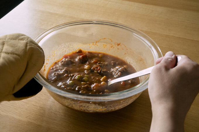 いったんラップを外してスプーンで混ぜ合わせ、再びラップをかけてさらに5分加熱する。ラップを外し、スプーンで全体をしっかり混ぜ合わせる。ご飯を器に盛り、カレーをかける。