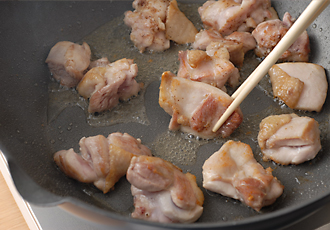 フライパンにごま油を強火で熱し、鶏肉を皮から入れて焼きつける。ときどきころがして、全体にこんがりと焼き色をつける。