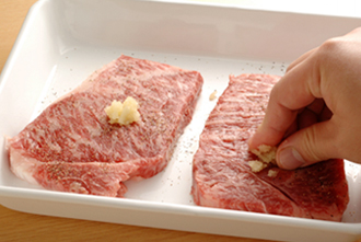 牛肉に塩、こしょうをふり、にんにくを全体にすり込む。牛肉は短時間でさっと焼きあげるので、肉は調理の前に常温に戻しておいたほうがよい。冷蔵庫に入っていた肉なら、20～30分は室温に出しておいて。