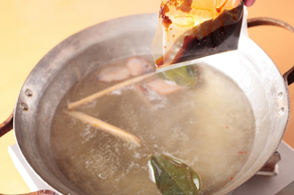 鍋に湯5カップを沸かし、鶏ガラスープの素を溶かし、あればハーブ類を入れる（なくてもよい）。トムヤムスープの素、ナンプラーを加えて溶かす。しめじ、しいたけを入れ、ひと煮立ちしたら豚肉、魚のすり身団子を加える。