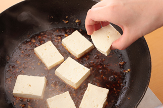 フライパンにごま油大さじ1/2を中火で熱し、にんにく、しょうがを炒める。香りが出てきたらAを加えて混ぜ合わせる。煮立ったら豆腐を加え、豆腐が温まるまで煮る。かきを戻し入れ、全体にからめてひと煮して火を止める。器に盛り、香菜を添える。