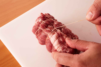 豚肉は全体に塩をまぶし、たこ糸を全体に巻きつけて形をととのえる（こうすると、形がくずれず肉がよくしまる）。