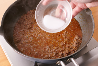 フライパンにごま油小さじ1とにんにく、しょうがを入れて中火にかけて炒める。香りが出てきたらみそ、豆板醤を加えて炒める。ひき肉、酒を加えて炒め、肉の色が変わったらだし汁を加える。煮立ったらアクを取り、さらに5分ほど煮る。水溶き片栗粉を加えて混ぜ、少しとろみがついたらバットに広げて冷ます。2のなすを加えて混ぜ、器に持ってねぎをのせる。