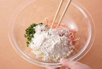 玉ねぎは薄切り、万能ねぎは小口切りに切ってボウルに入れる。桜えび、塩、薄力粉を加えて全体をさっと混ぜ合わせる。
