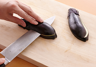 なすはへたつきのまま縦半分に切り、さらに厚みの半分のところに切り込みを入れて水にさらしておく。ボウルにひき肉だねの材料を入れてしっかり練る。