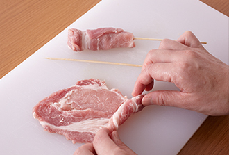 ソテー、とんカツ用の豚肉は4～6等分の棒状に切り、竹串をさす。しょうが焼き用の豚肉は端からくるくると巻いて棒状にし、軽く縫うように竹串をさす。