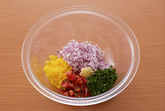 野菜ソースを作る。紫玉ねぎはみじん切りにする。パプリカは種を取ってみじん切りにする。プチトマトは縦6等分に切り、さらに長さを半分に切る。ソースの材料を全てボウルに入れ混ぜ合わせる。