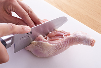 鶏肉は関節のところに包丁の刃を入れ、2つに切り離す。全体に塩小さじ1/2をもみ込む。