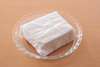 豆腐はペーパータオルに包み耐熱皿にのせ、電子レンジ（600W）で3分加熱して水きりし、厚さ1センチに切る。