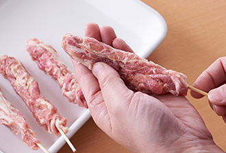 豚肉1枚（1/8量）を手で細長くまとめ、竹串を刺してぎゅっと握り、形をととのえる。残りも同様にして全部で8本作る。