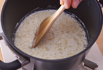 カッテージチーズを作る。直径20センチの鍋に牛乳を入れて弱火にかけ、そのまま4～5分かけて60℃くらいに温める（鍋肌に小さな泡が出始めるくらい。沸騰させないように）。酢を回し入れ、火を止めて、木べらで鍋底をこするように10回ほど混ぜると牛乳が分離してくるので、そのまま5分ほどおく。