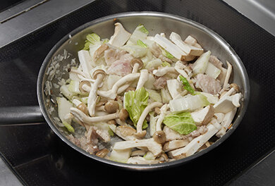 オリーブオイルでニンニクを炒め、色がつき始めたら豚肉を加え炒める。続けて白菜、キノコ、玉ねぎを加えて炒める。