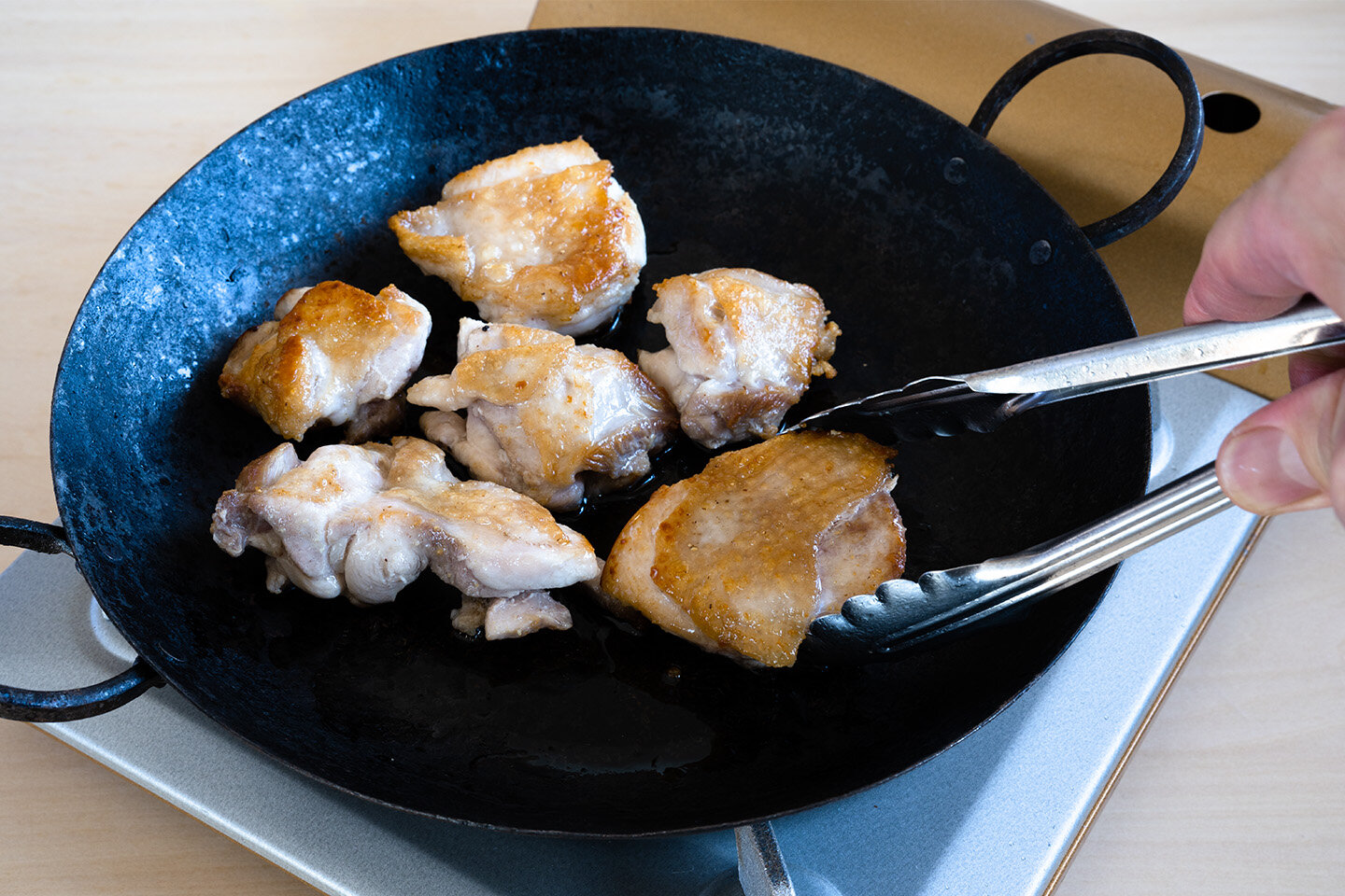 鉄のフライパン（鉄のフライパン以外でもOK）に残りのサラダ油を入れて中火で熱し、鶏肉の皮を下にして並べる。3分焼いたら上下を返し、さらに3分焼いて取り出す。