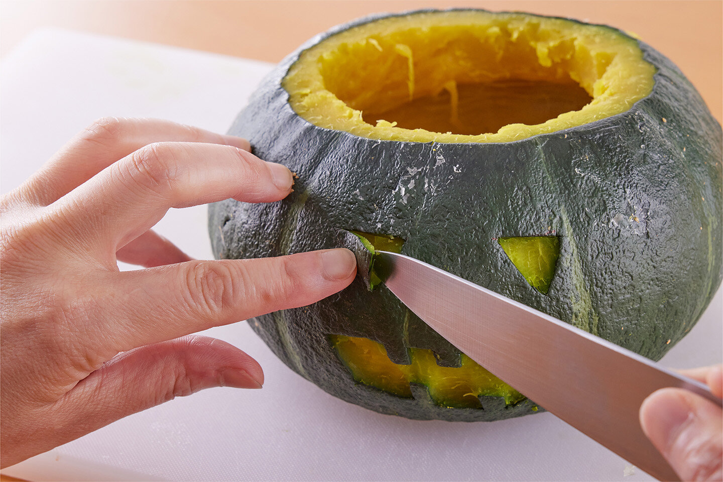 かぼちゃの皮に、ペティナイフなどで切り込みを入れ、口や目を切り取る。4を中に詰める。