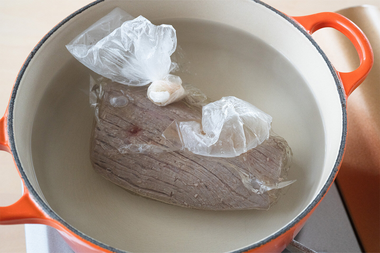 牛肉を耐熱性のある食品用ポリ袋に入れ、Aの塩を加えてもみ込む。サラダ油も加えてなじませ、空気を抜いて口を閉じる。<br>厚手の鍋にたっぷりの湯を沸かし、火を止める。牛肉を袋ごと入れ、湯からはみ出さないように落としぶたなどをのせ、30分ほどおく。湯が冷めたら、牛肉を袋から取り出し、ペーパータオルで汁けを拭く。   